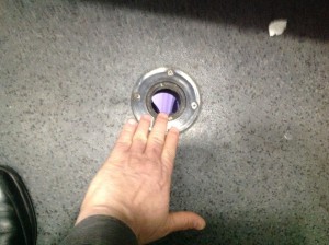 Foto: Loch im Boden einer Railjet Toilette, Größervergleich mit Hand.